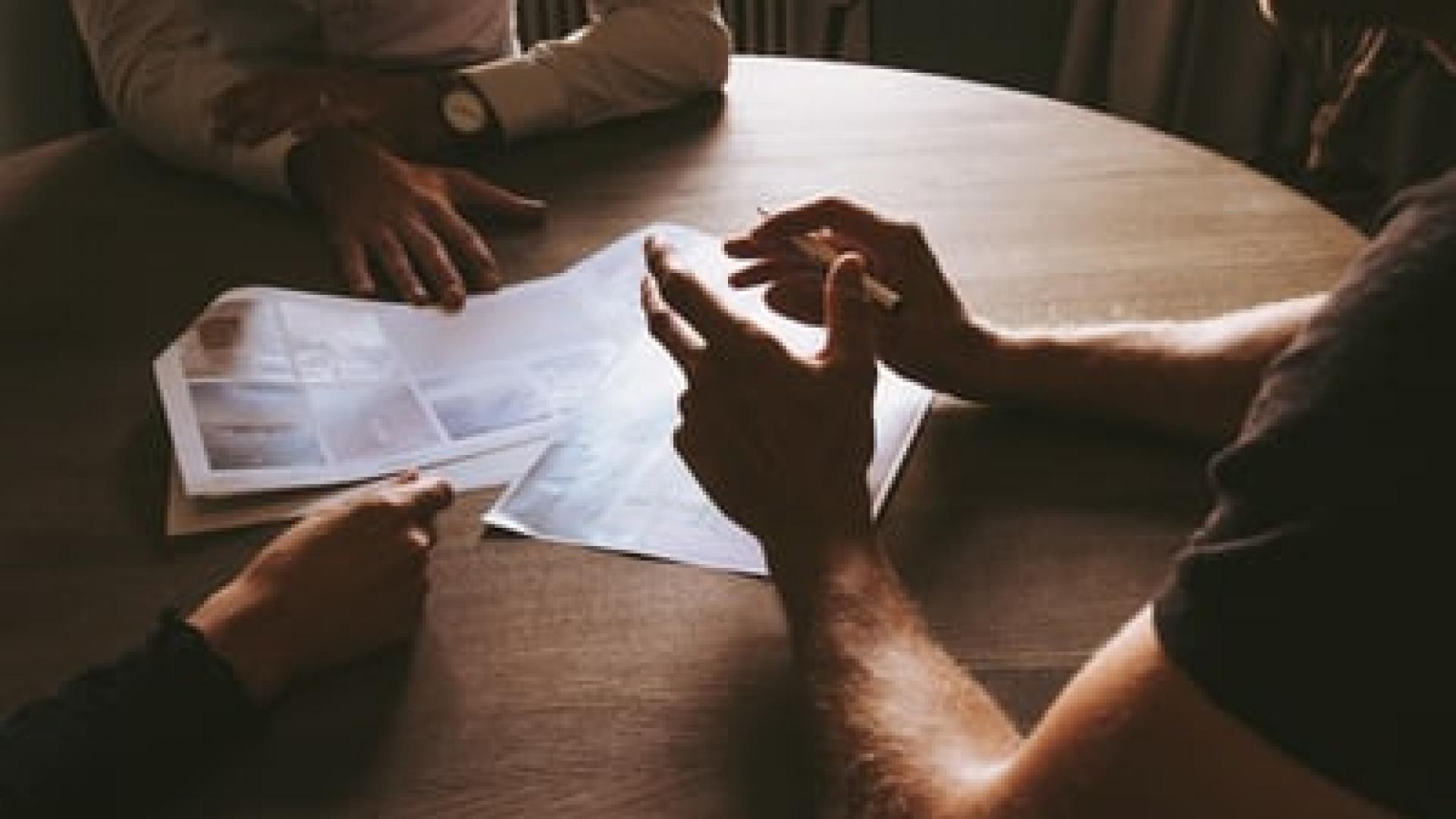 3 personnes autour d'une table qui échangent sur le coaching